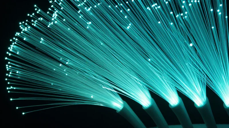 Why Low Latency is the Critical Metric for Next-Gen Networks Conceptual visualization of low latency data transmission with synchronized light pulses flowing through fiber optics.