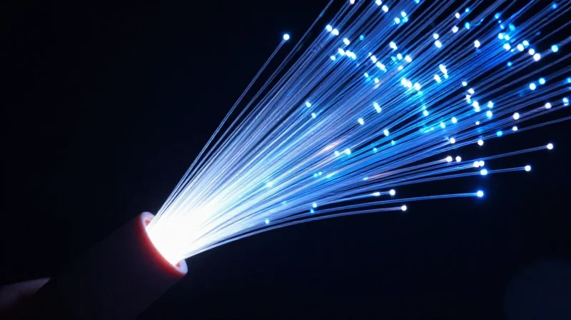 The Evolution of Modern Network Infrastructure and the Role of Optics Abstract visualization of glowing fiber optic cables representing high-speed data transmission.