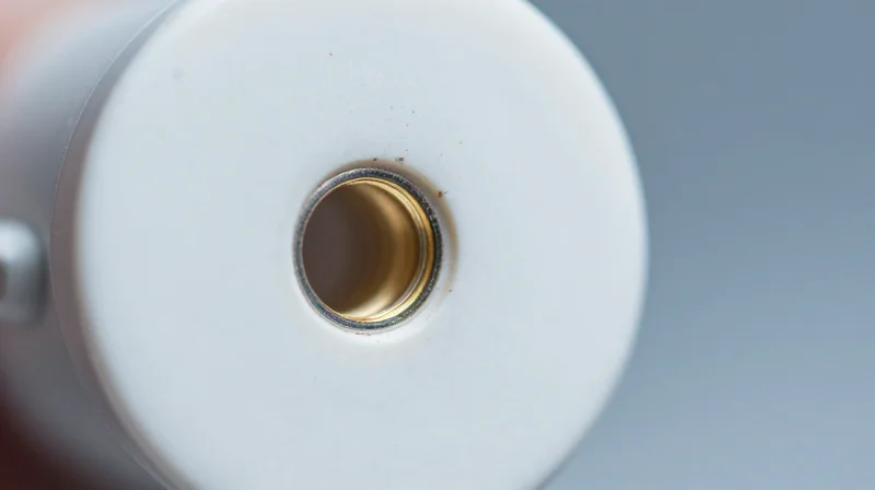 Microscopic view of a circular fiber optic ferrule with small dust particles on the surface